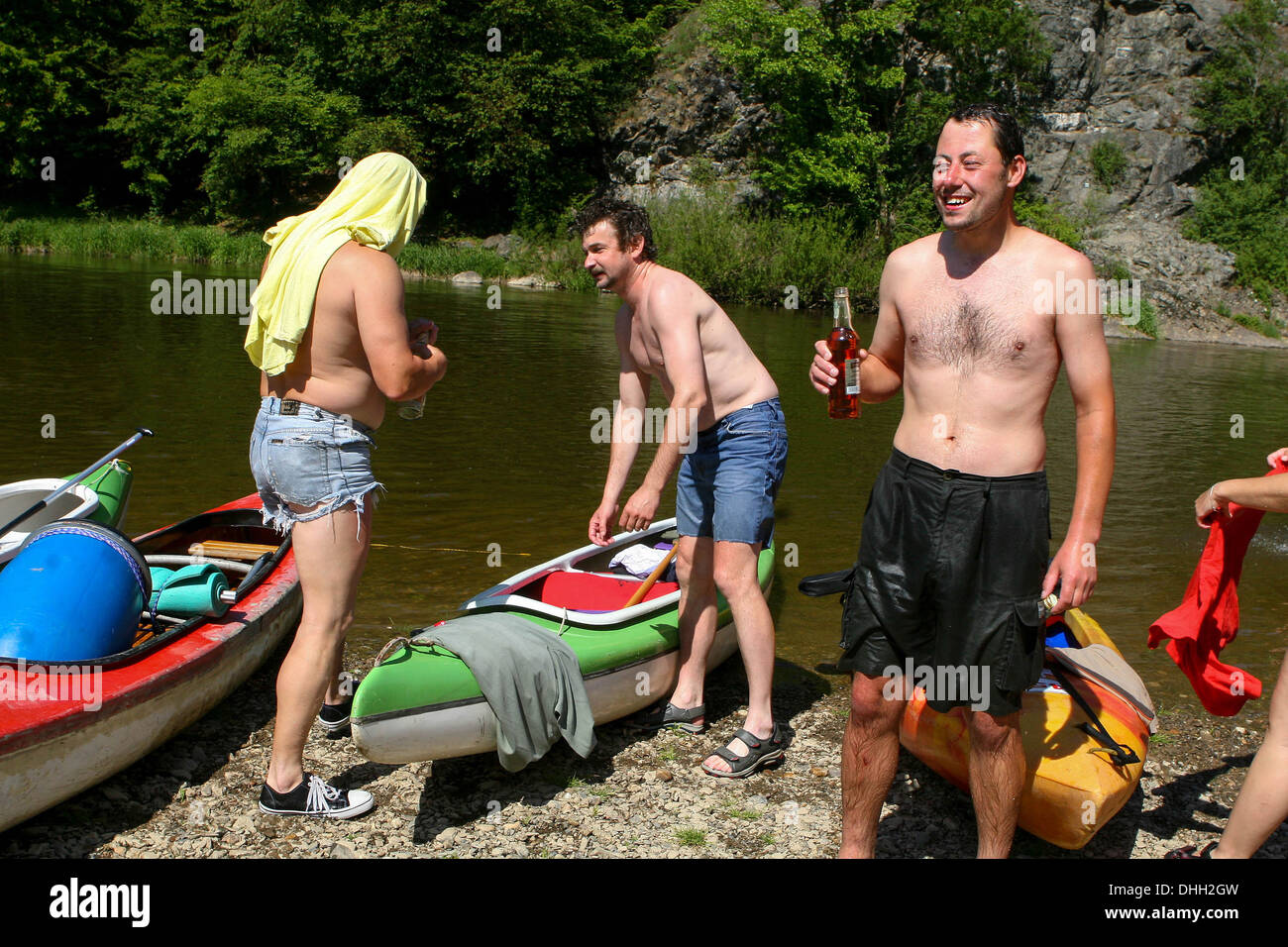 Homme avec une bouteille d'alcool Les personnes en canoë sur la rivière Berounka, République Tchèque Banque D'Images