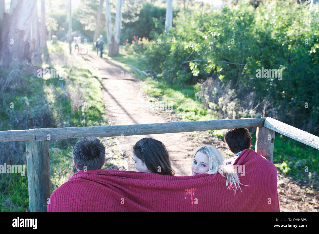 Groupe de quatre amis assis sur le porche avec couverture autour de Banque D'Images