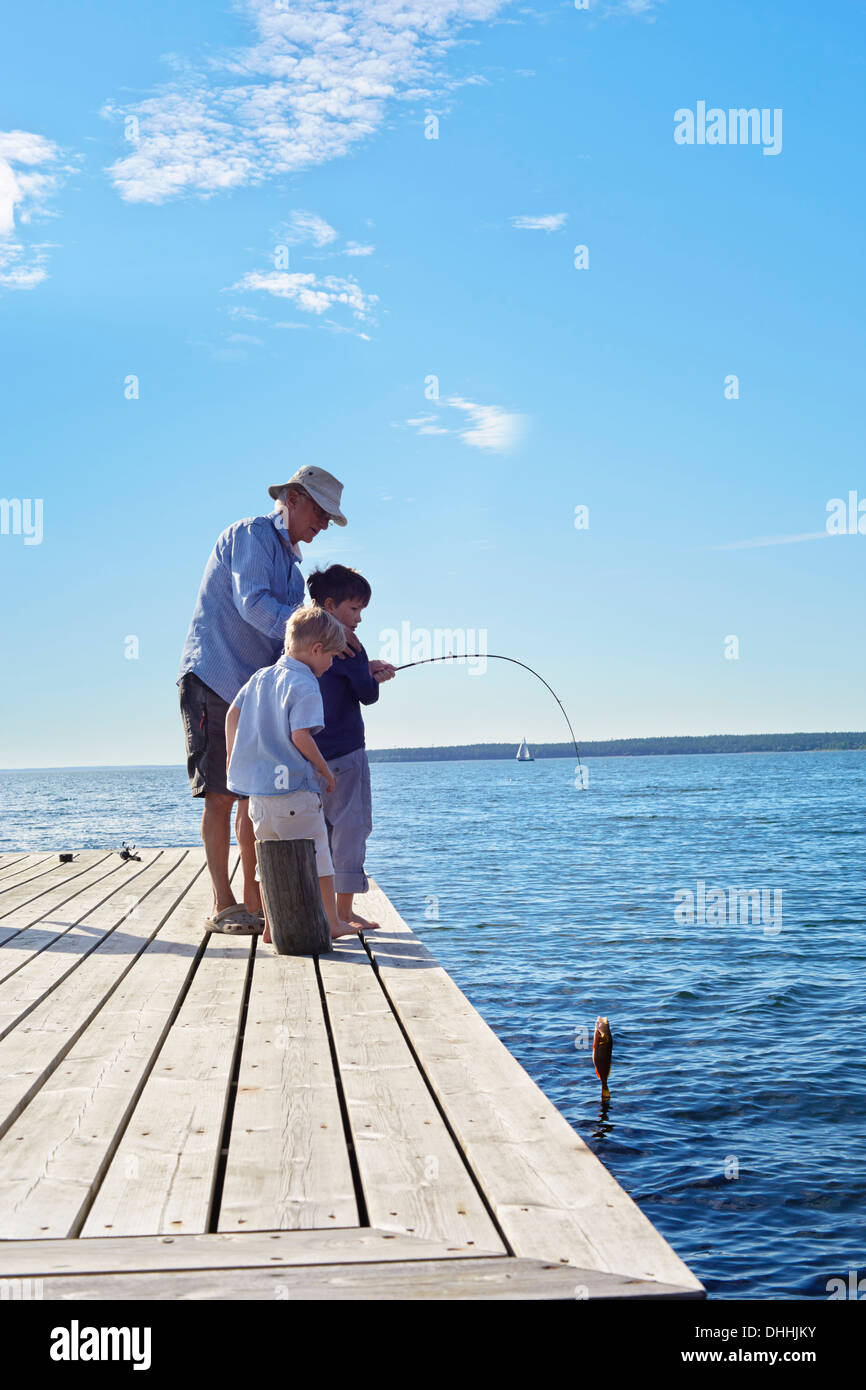 Grand-père et ses petits-fils pêche, Utvalnas, Suède Banque D'Images