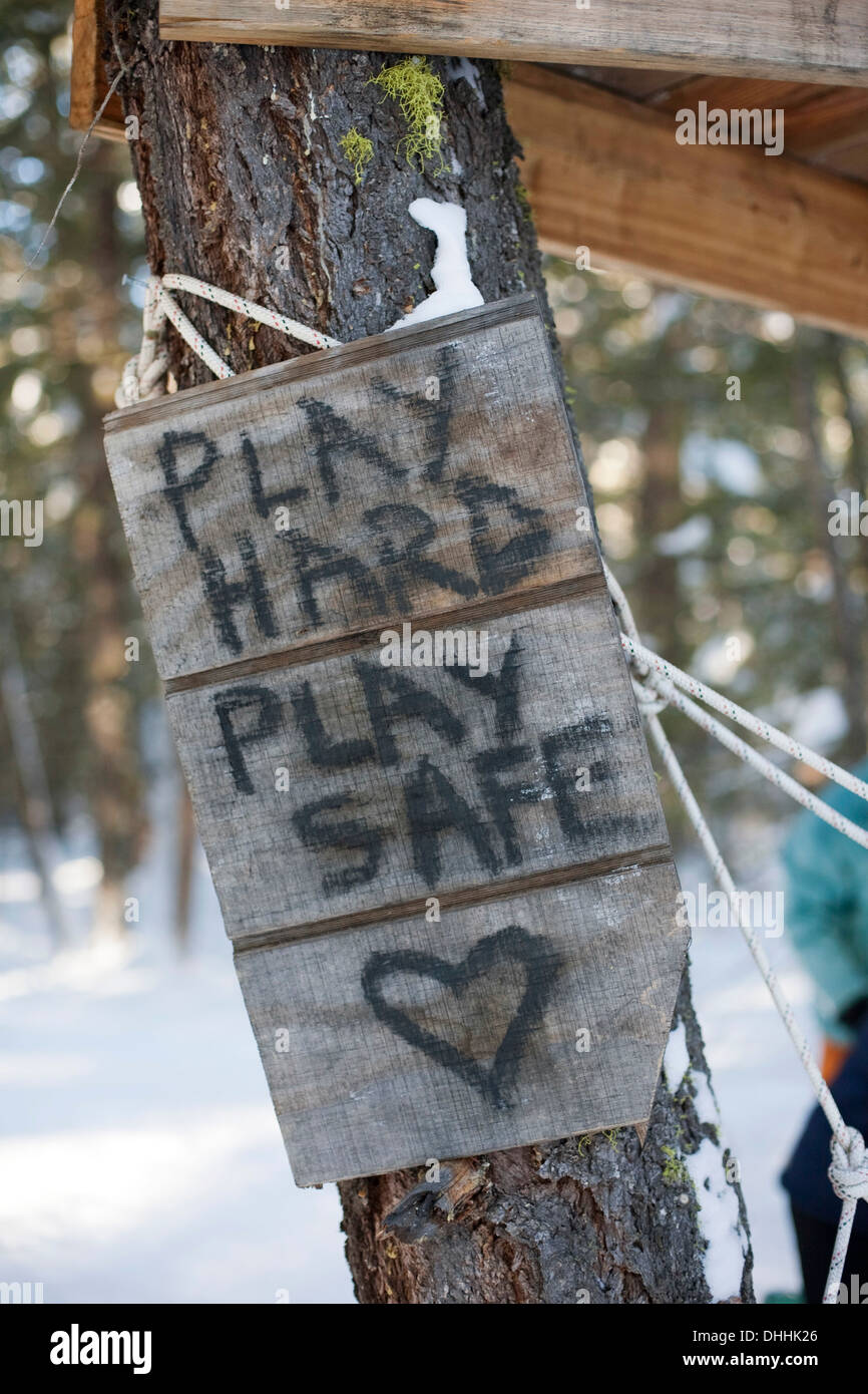 "Play hard, play safe' sign on tree Banque D'Images