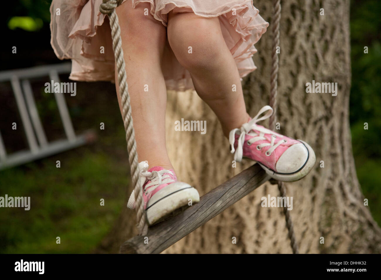 Cropped shot of girl's jambes, échelle de corde d'escalade Banque D'Images