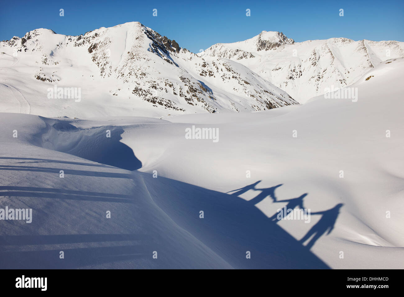 Ombre de quatre amis se tenant par la main dans la neige, Kuhtai, Autriche Banque D'Images