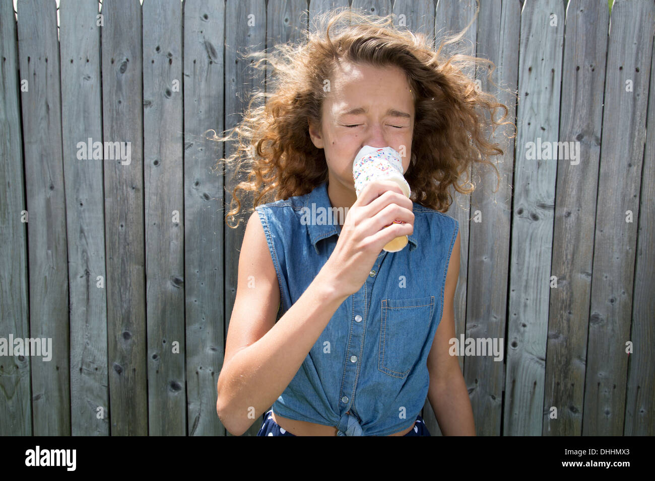 Teenage girl eating ice cream cone Banque D'Images