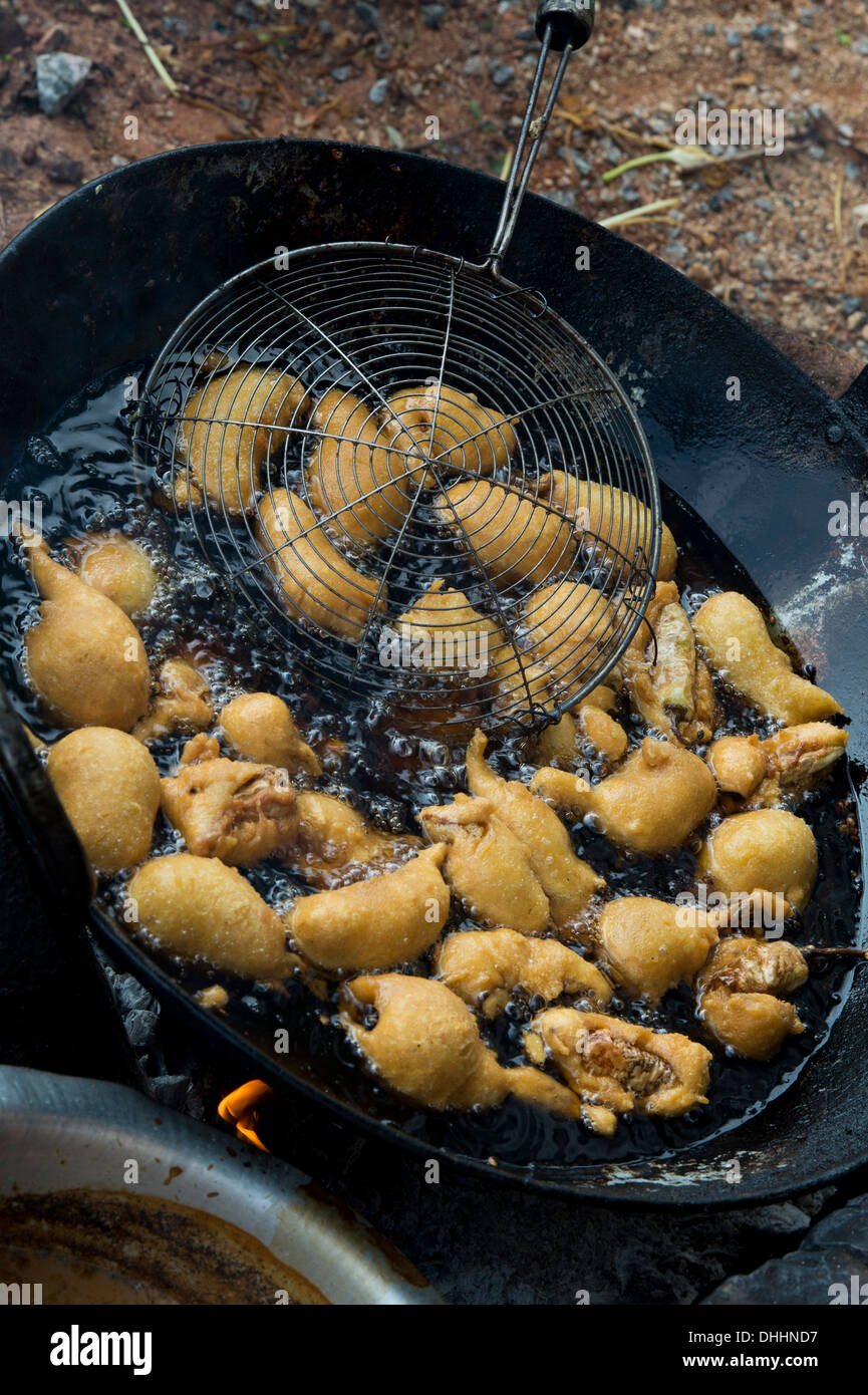 La cuisine frite chili battues dans la rue dans un village de l'Inde rurale. L'Andhra Pradesh, Inde Banque D'Images