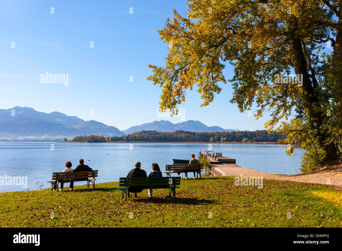 Les touristes assis sur des bancs au lac de Chiemsee, ou l'île de Frauenchiemsee Fraueninsel, Chiemsee, Upper Bavaria, Bavaria, Germany Banque D'Images