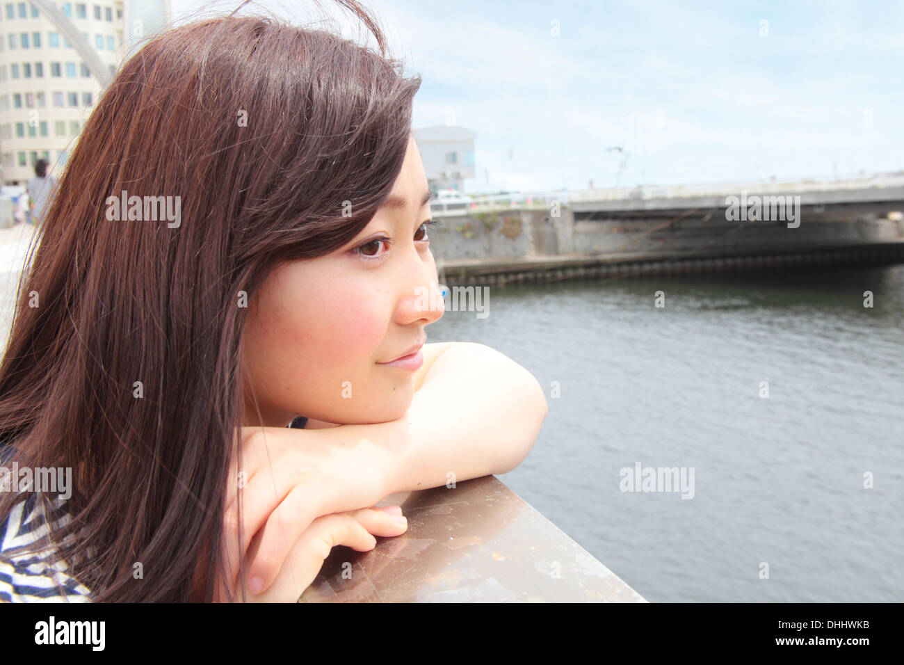 Young woman leaning on les garde-corps avec vue sur la rivière Banque D'Images