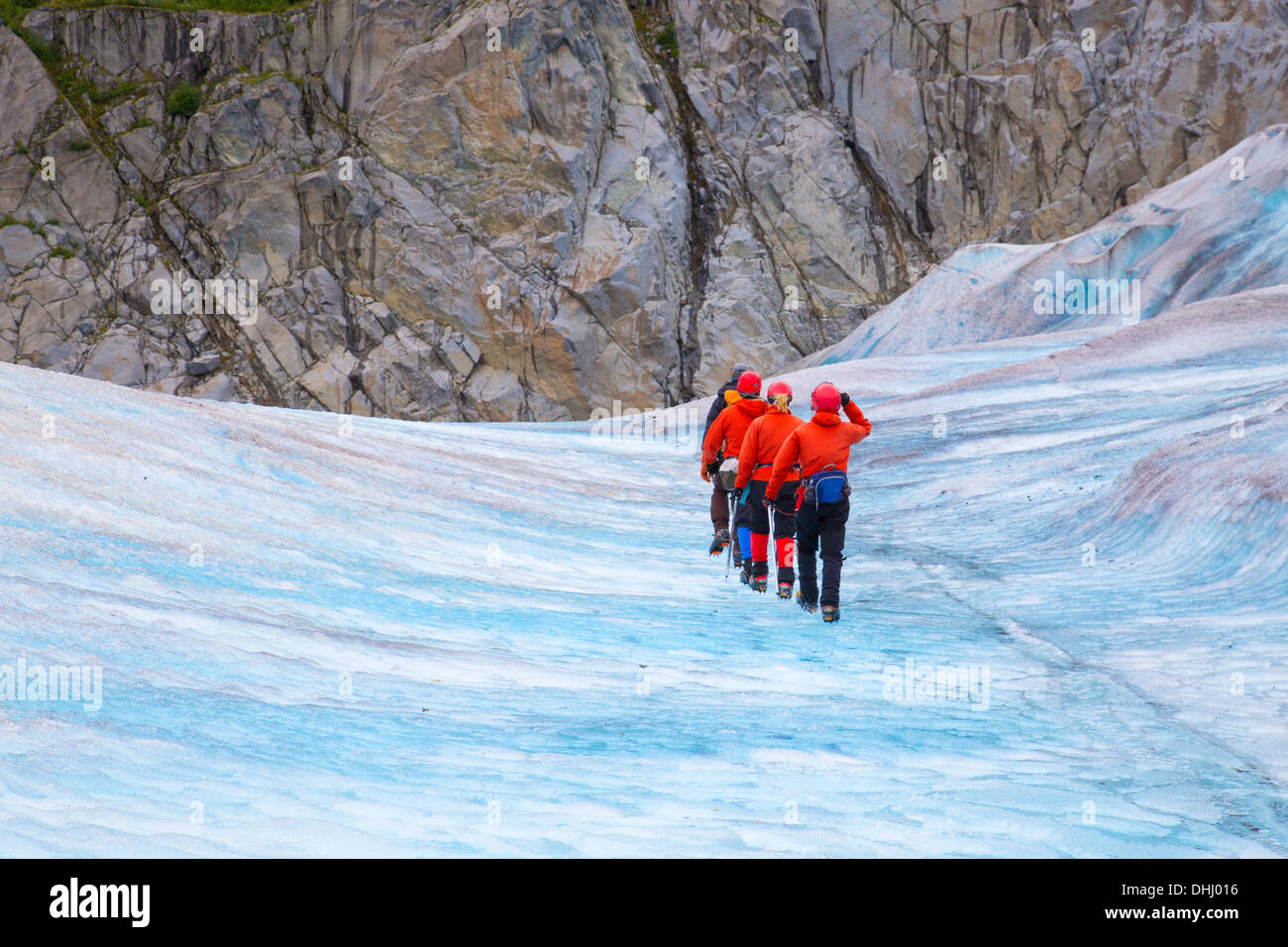 Quatre personnes marchant sur Mendenhall Glacier, Alaska, USA Banque D'Images