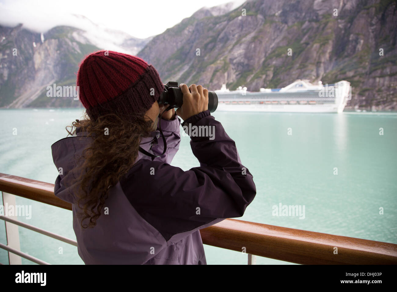 Woman using binoculars on cruise ship, Ketchikan, Alaska, USA Banque D'Images