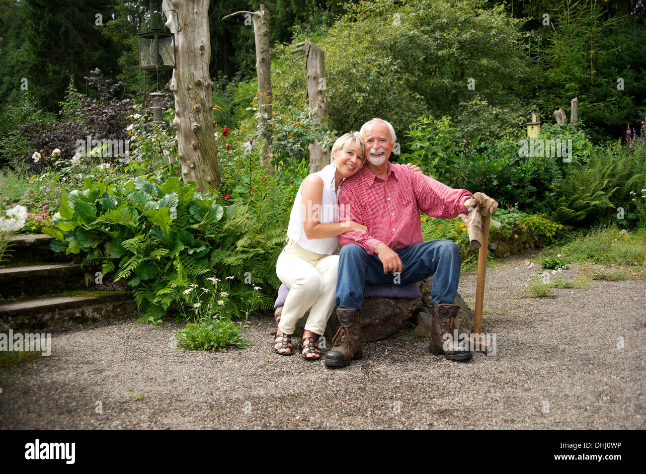 Portrait of senior couple sitting in garden Banque D'Images