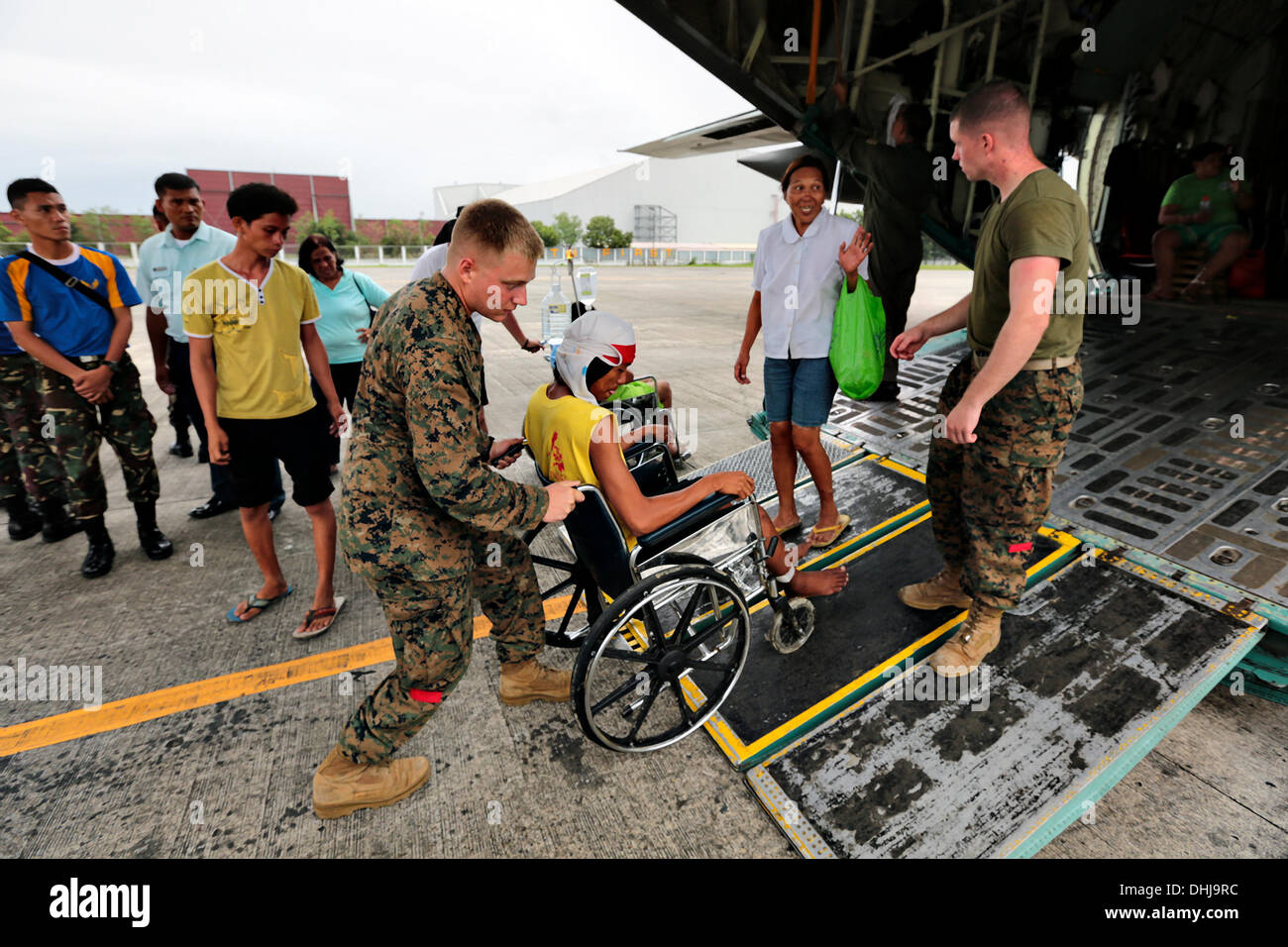 Les Marines américains portent un philippin blessé au dos d'un KC-130J Super Hercules à Villamor Air Base le 11 novembre 2013 à Manille, aux Philippines. Les États-Unis ont rejoint les efforts de secours à la suite des ravages causés par le super typhon Haiyan qui est soupçonné d'avoir tué 10 000 personnes dans les Îles Philippines. Banque D'Images