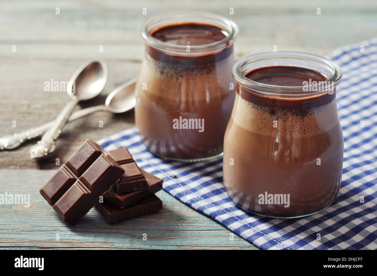 Panna cotta au chocolat dans des bocaux en verre sur fond de bois Banque D'Images