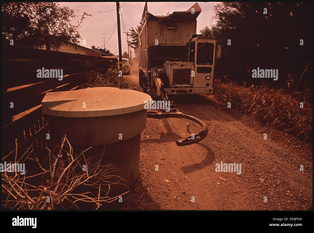 Le bras mécanique d'un camion à ordures soulève des conteneurs de 320 gallons et les vide, une démonstration de la technologie moderne de collecte des déchets en action. Banque D'Images