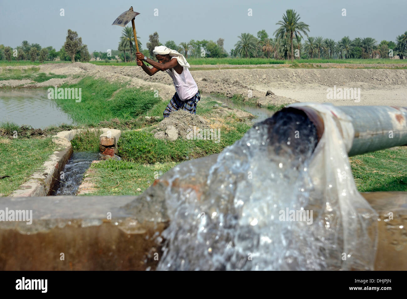 Le Pakistan, Punjab, village Basti Walla Lehar, l'homme le nettoyage ethnique un fossé d'irrigation Banque D'Images