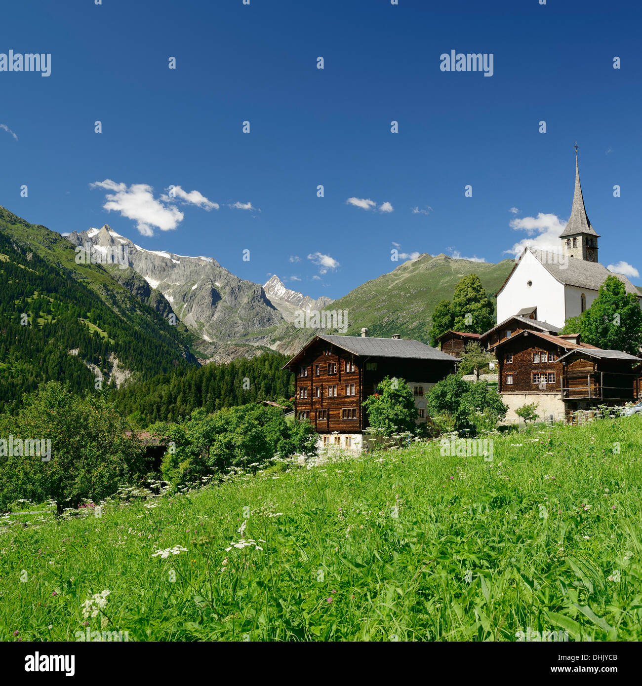Église et maisons traditionnelles en face des Alpes Bernoises, Ernen, vallée de Binn, vallée du Rhône, Valais, Suisse Banque D'Images