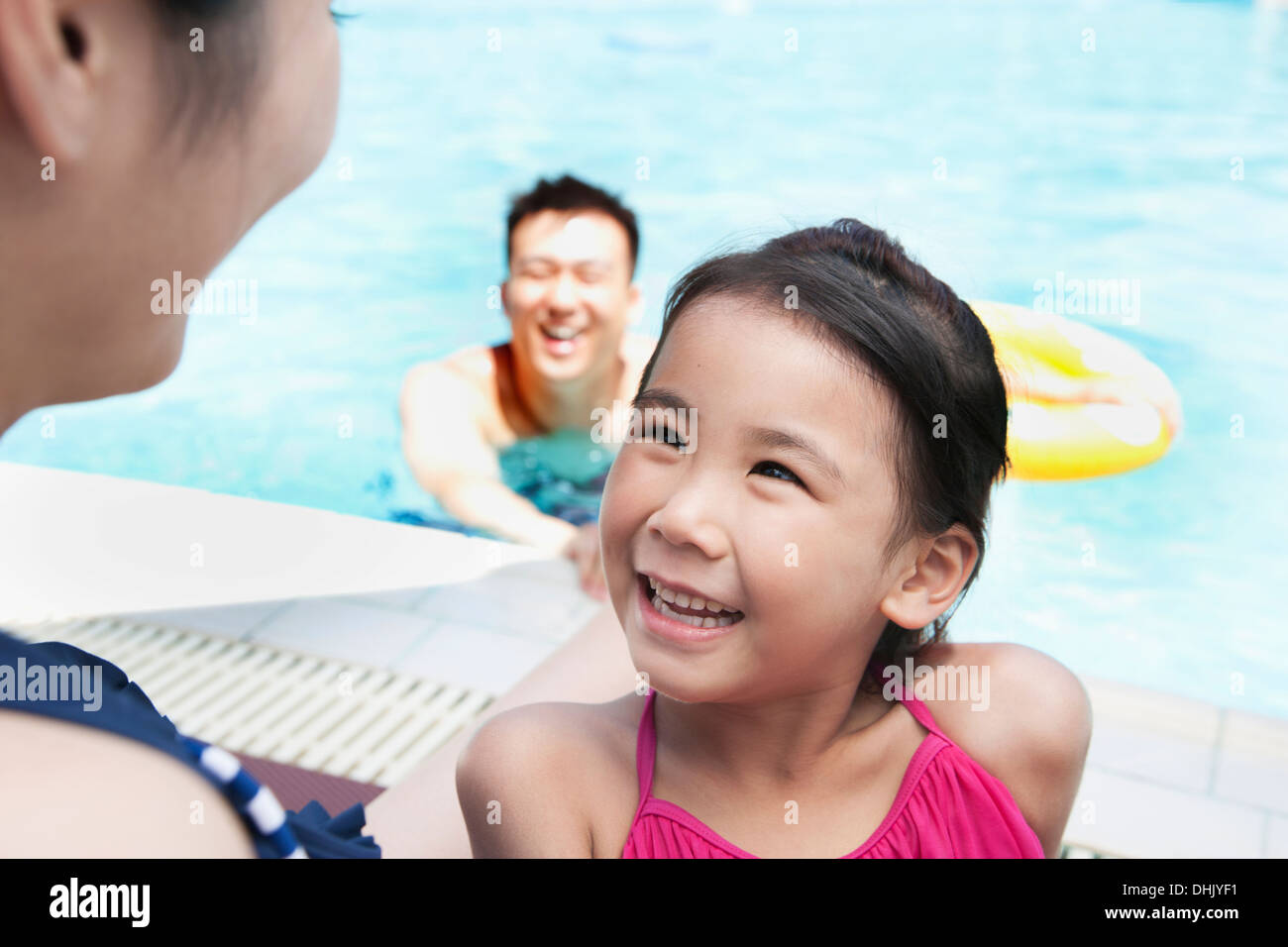 Cute little girl à sa mère au bord de la piscine Banque D'Images