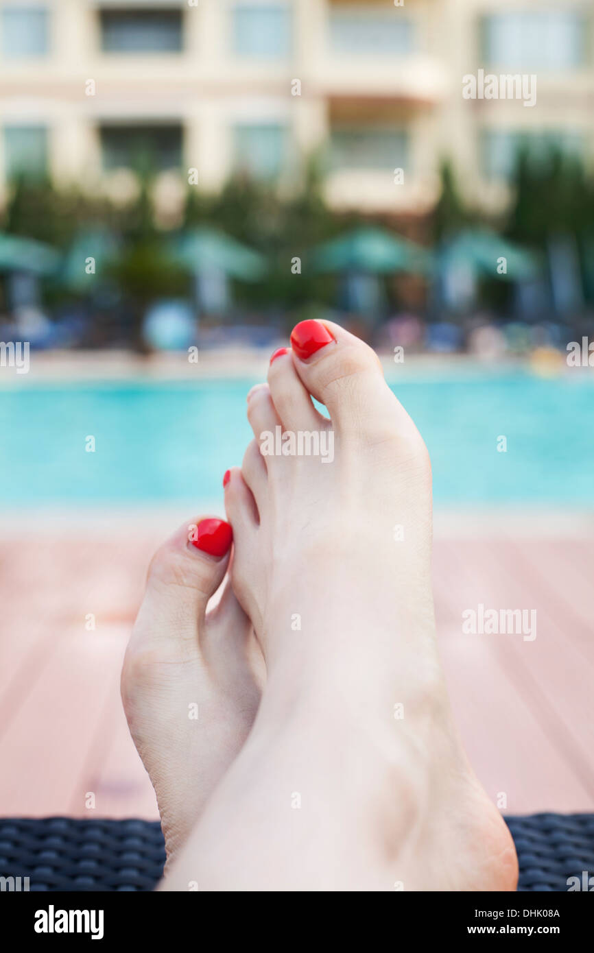 Close up of young woman's pieds sur le bord de la piscine Banque D'Images
