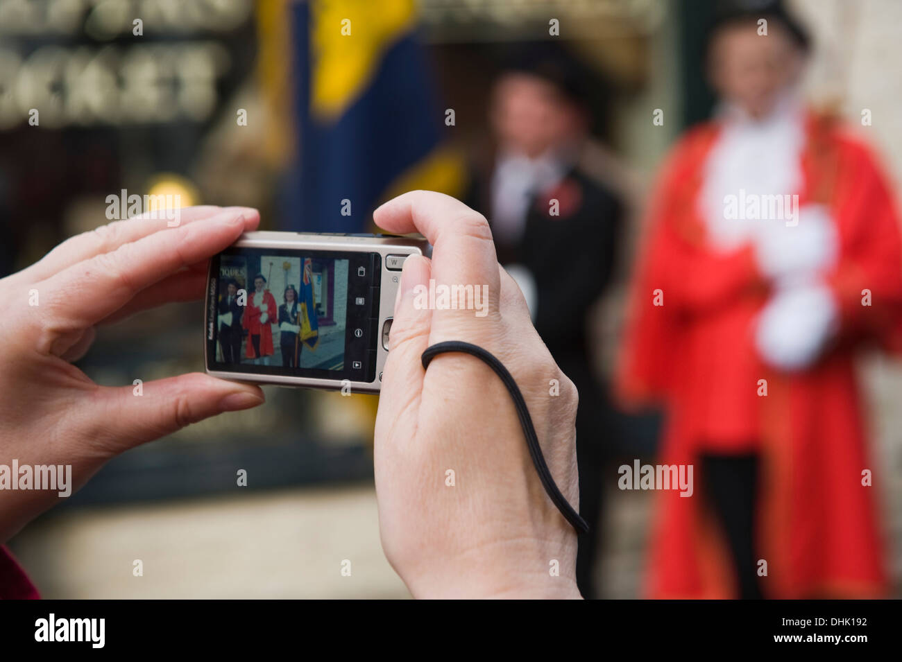 Femme à l'aide d'un appareil photo numérique pour la photographie souvenir parade de dimanche à Hay-on-Wye Powys Pays de Galles UK Banque D'Images