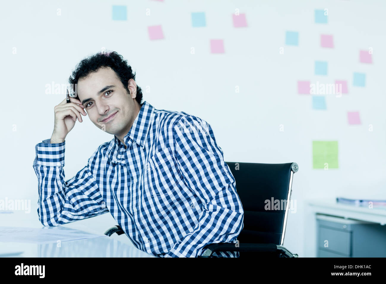 Portrait of young businessman dans une chemise à carreaux à son bureau. Banque D'Images