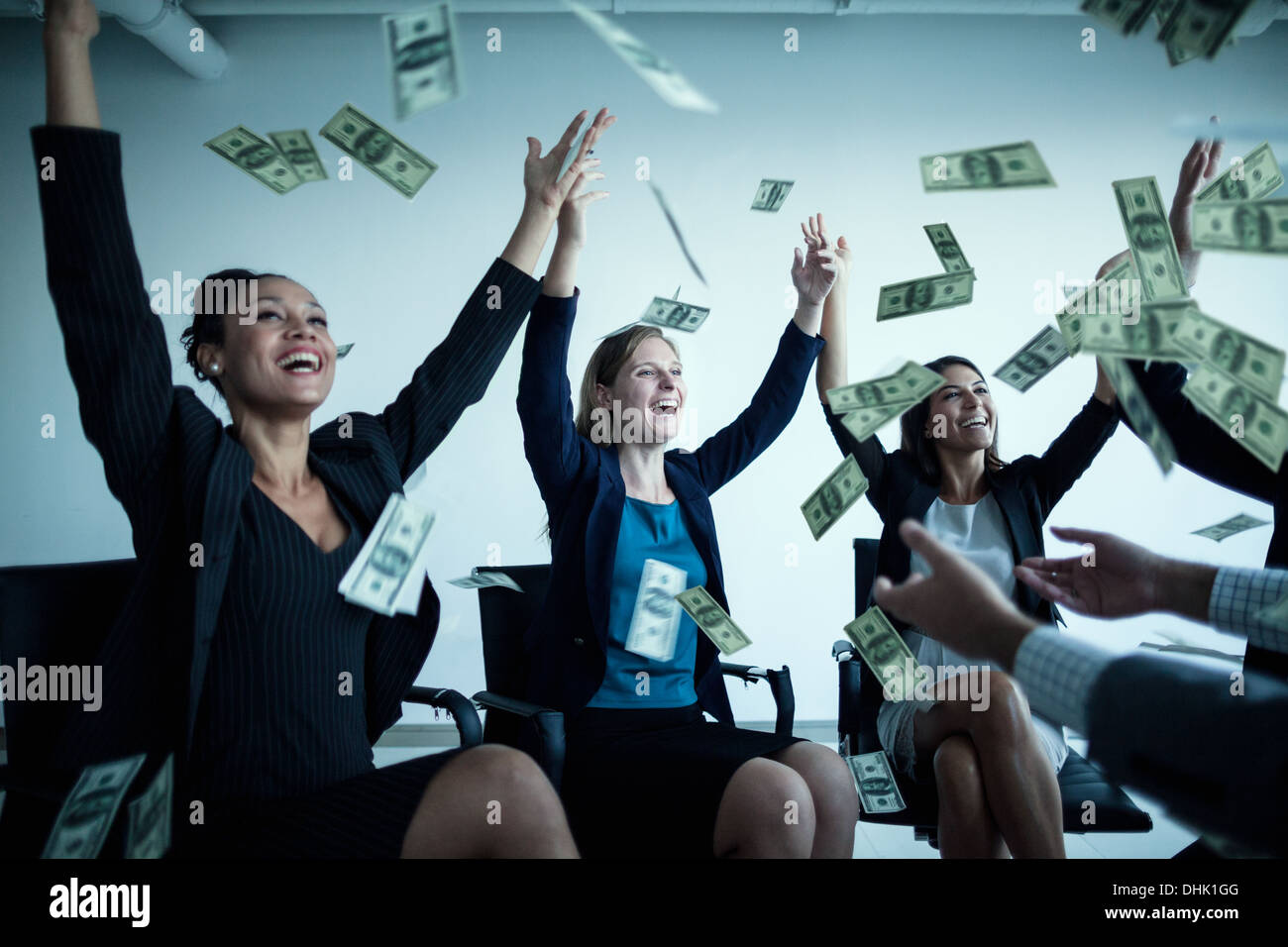 Les gens d'affaires avec bras levés en jetant de l'argent en l'air Banque D'Images