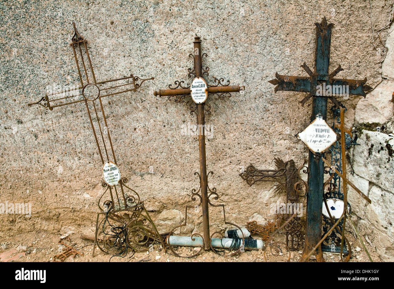 Old rusty metal burial traverse appuyé contre un mur de l'église dans un cimetière français. Banque D'Images