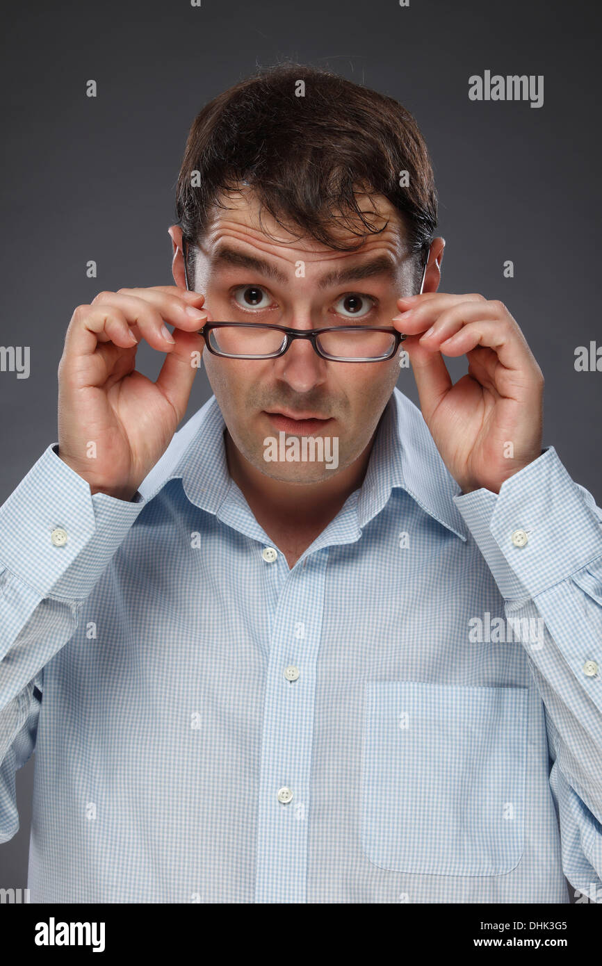 Portrait d'un homme à la recherche au cours de la ses lunettes, studio shot Banque D'Images