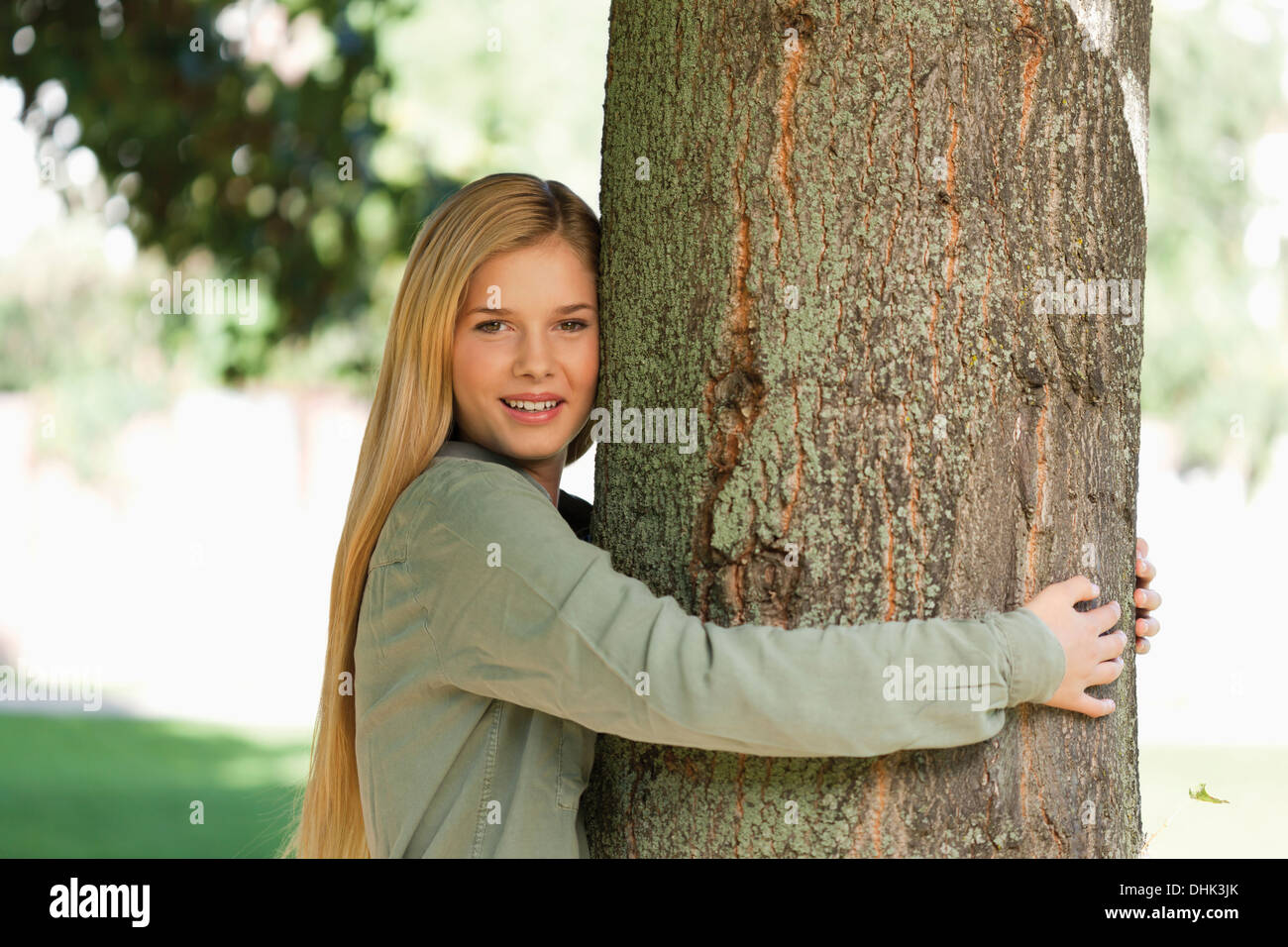 Allemagne, Düsseldorf, young woman hugging tree trunk Banque D'Images