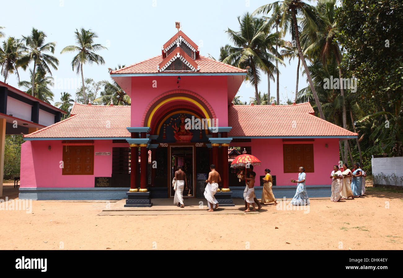 Un groupe de femmes avec des offrandes et un prêtre entourant un temple hindou à Varkala, Inde, Banque D'Images