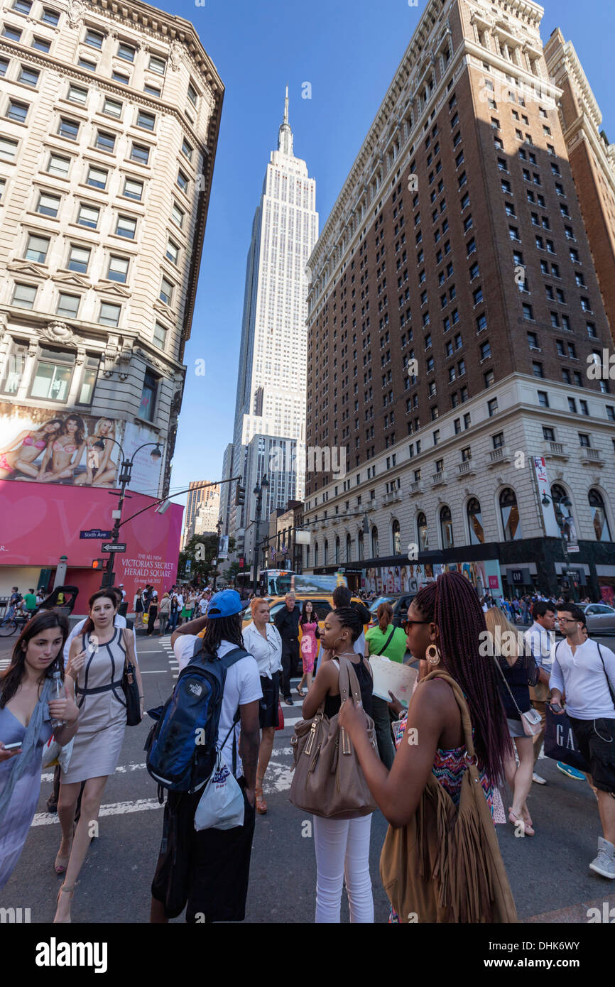 Les touristes dans les rues, l'Empire State Building, Manhattan, New York Banque D'Images