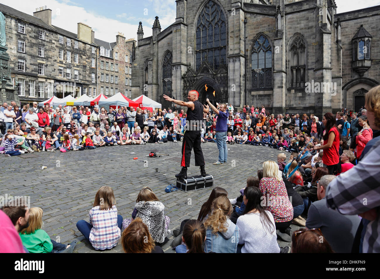 Mighty Gareth, artiste de rue, se prépare à manger le feu avec l'aide d'un volontaire lors du Festival International d'Édimbourg Fringe, en Écosse, au Royaume-Uni Banque D'Images