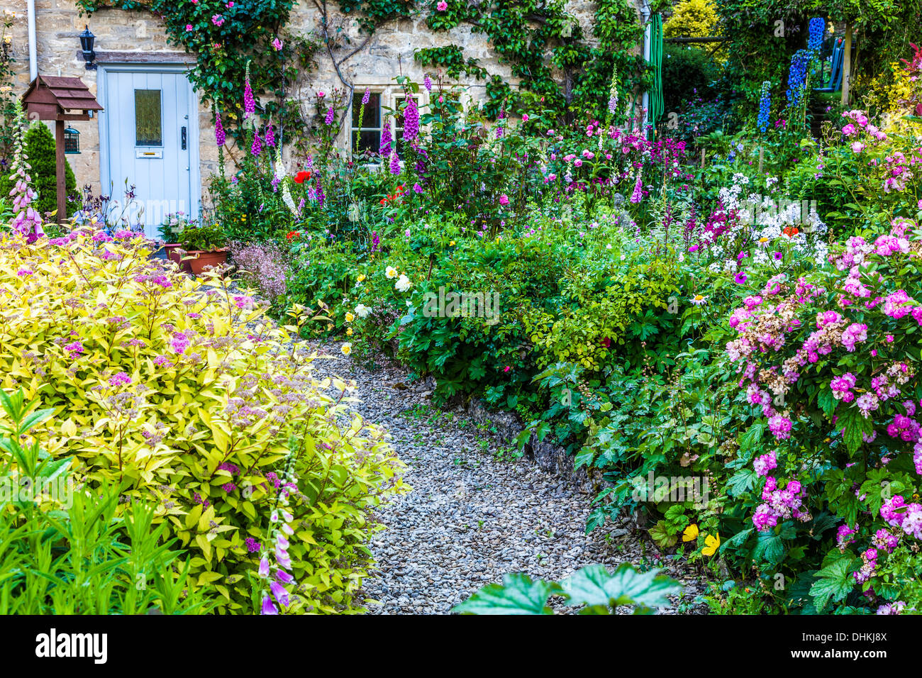 Un joli jardin de cottage anglais dans le village de Cotswold Bibury en été. Banque D'Images