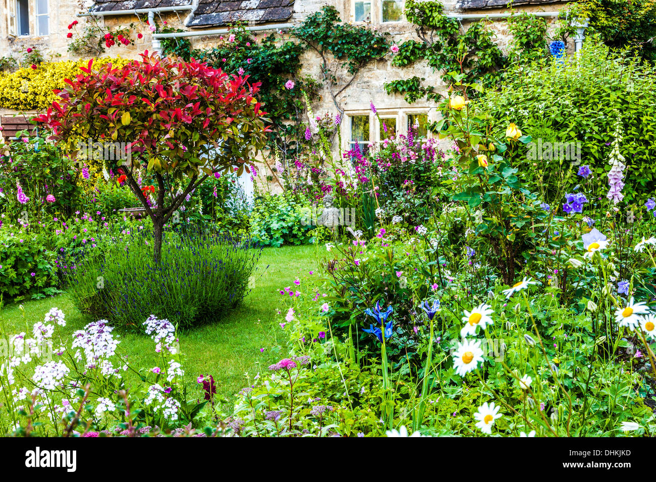 Un joli jardin de cottage anglais dans le village de Cotswold Bibury en été. Banque D'Images