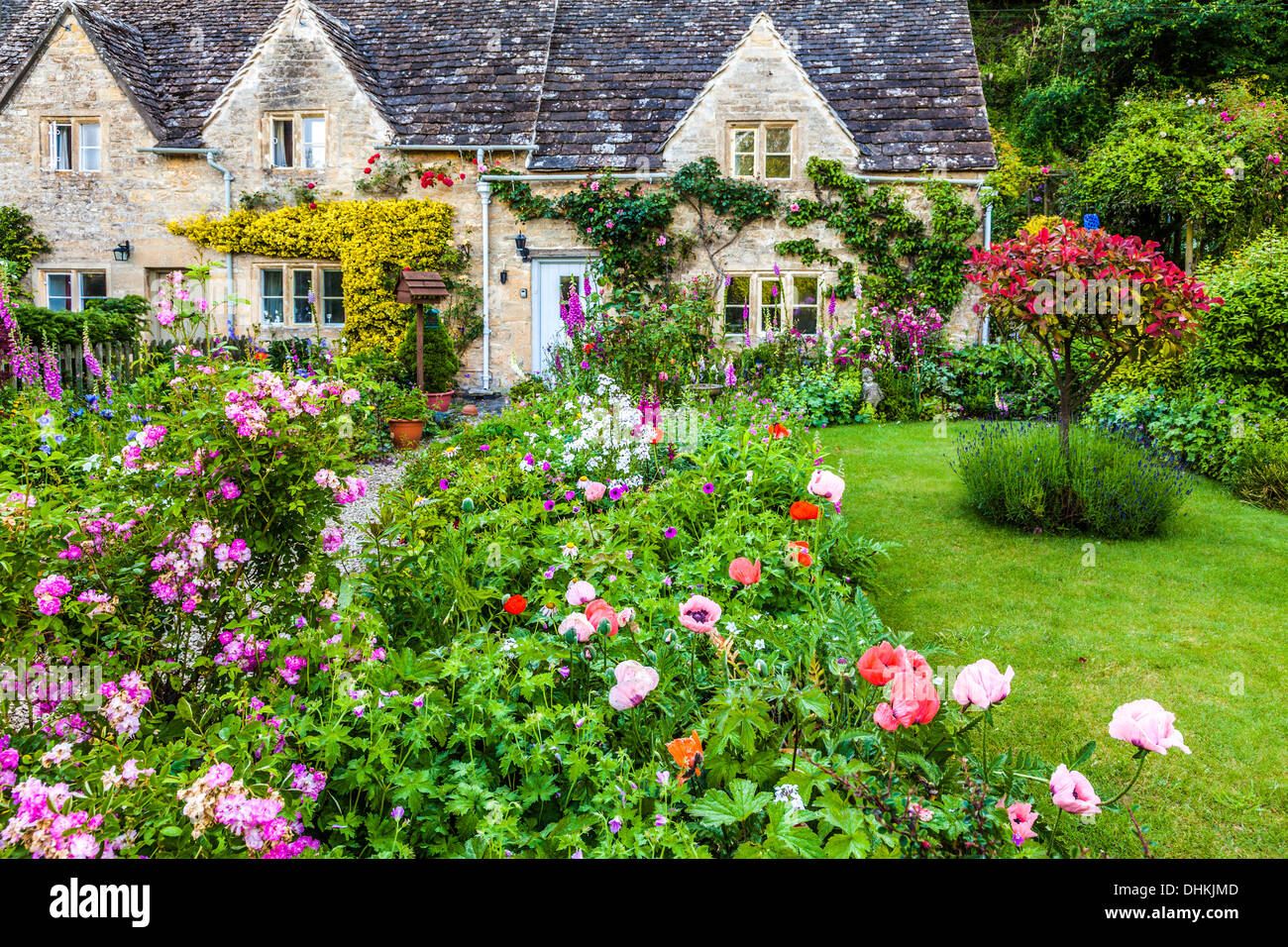 Un joli jardin de cottage anglais dans le village de Cotswold Bibury en été. Banque D'Images