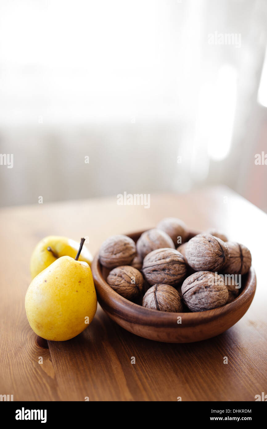 Les noix et les poires sur table en bois Banque D'Images