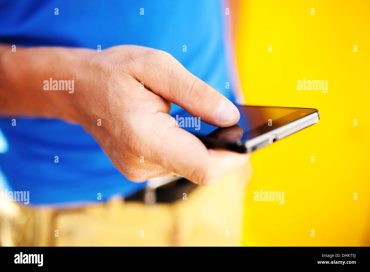 Jeune homme à l'aide de mobile smart phone, piscine d'été Banque D'Images