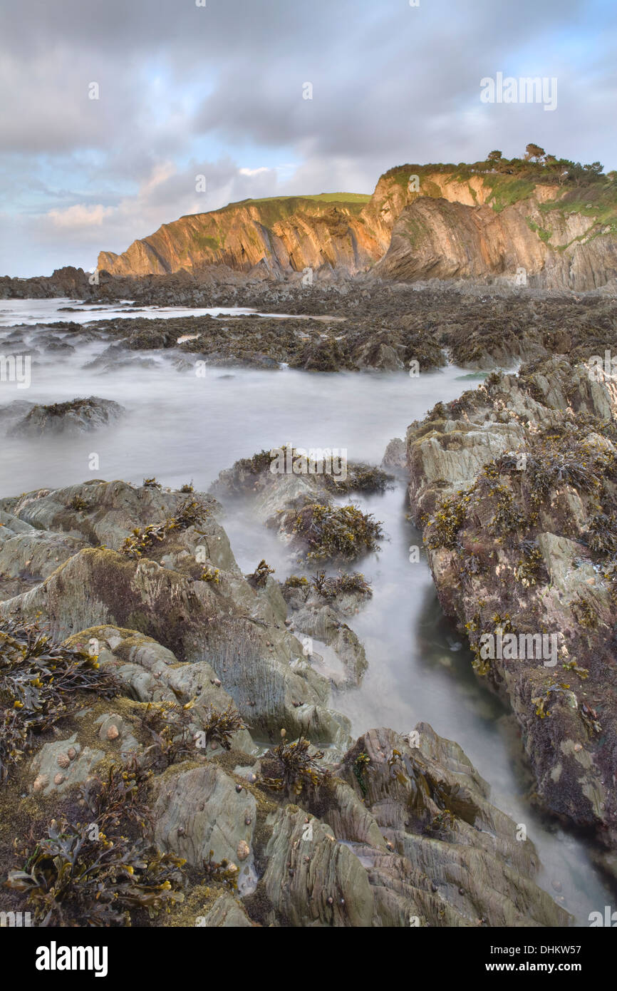 Coucher du soleil sur les rochers à Lee Bay, North Devon, Angleterre à marée basse montrant l'aspect des roches sous la mer. Banque D'Images
