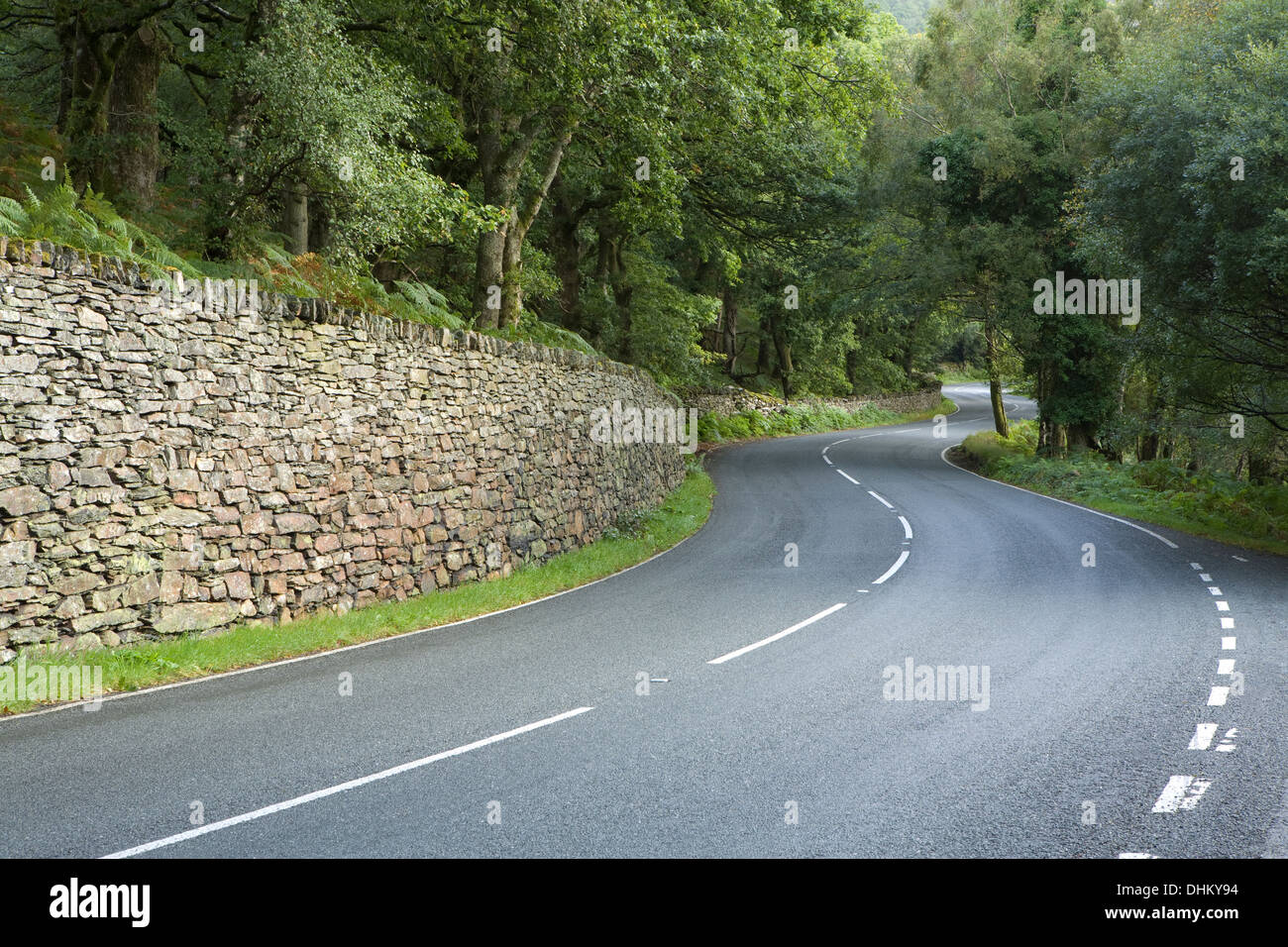 Un mur en pierre sèche lines l'intérieur d'un virage sur l'A498 en Gwynedd, Pays de Galles Banque D'Images