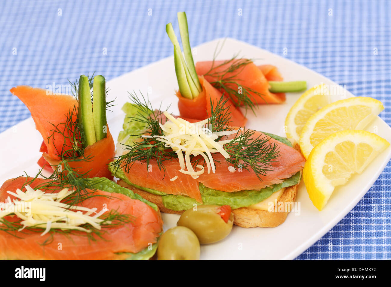 Sandwiches au saumon, fromage, laitue, les herbes sur la plaque, les olives et les citrons. Banque D'Images