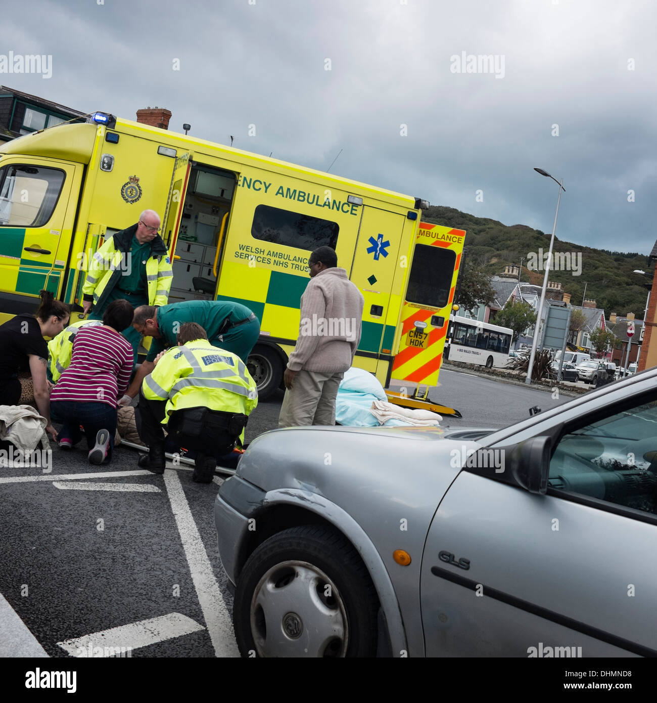 Les ambulanciers et les ambulanciers traiter un piéton blessé dans une collision avec une voiture, UK Banque D'Images