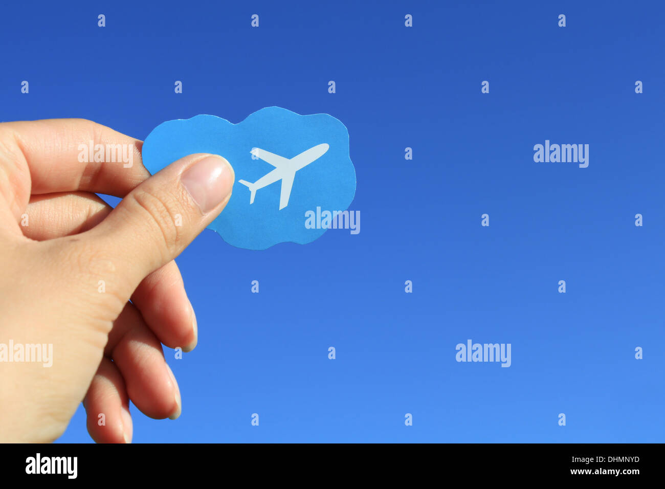 Main tenant peu petite icône photo flying airplane [plan] ciel bleu ciel clair [Contexte] simple Banque D'Images