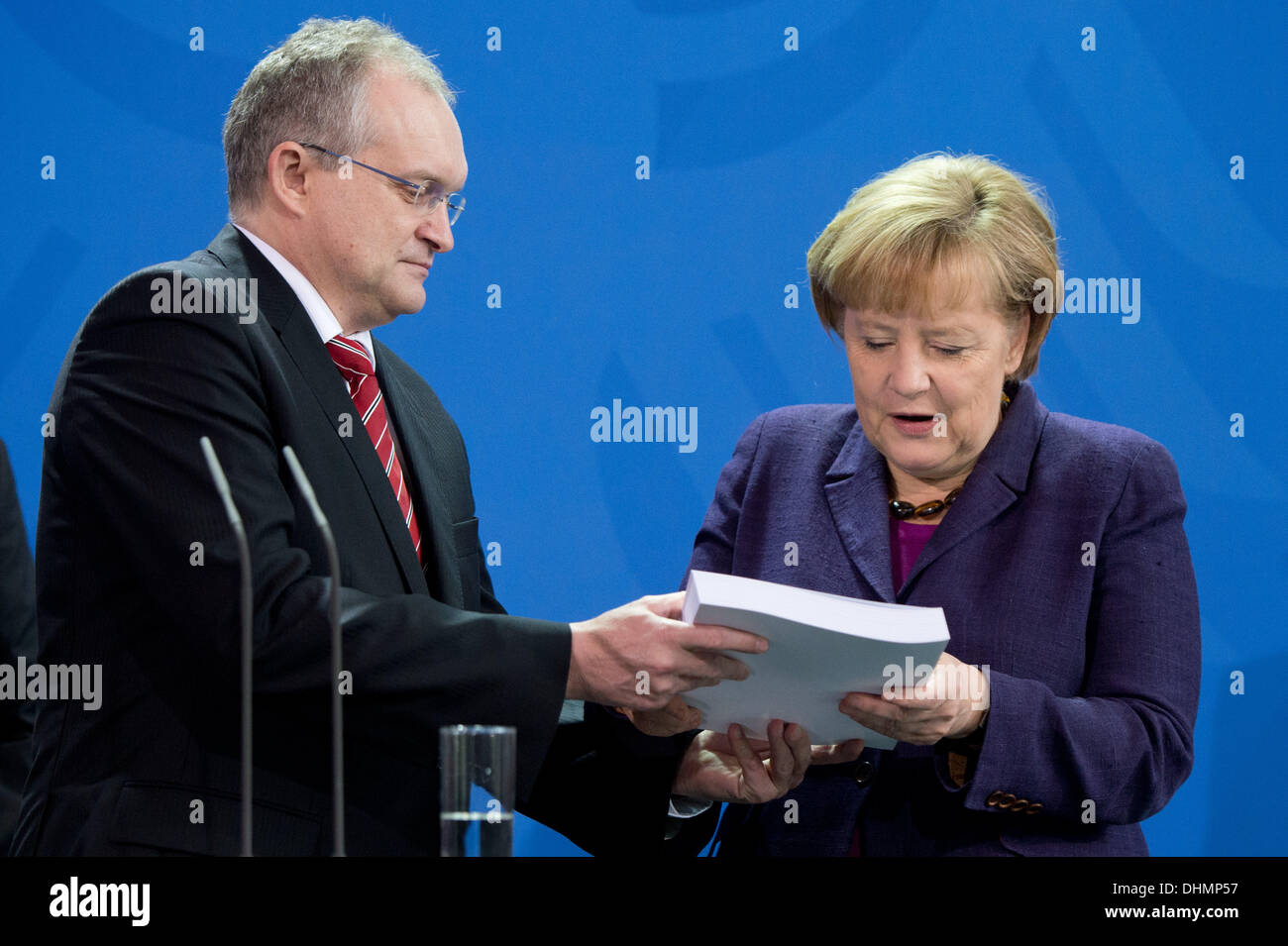 L'homme sage économique et président de l'Institut allemand de recherche économique, Christoph M. Schmidt jhands la chancelière Angela Merkel (CDU) le rapport de la sages économique au bureau du chancelier fédéral. Les sages économiques mettent en garde contre des dépenses élevées en raison des négociations de coalition. Photo : MAURIZIO GAMBARINI Banque D'Images