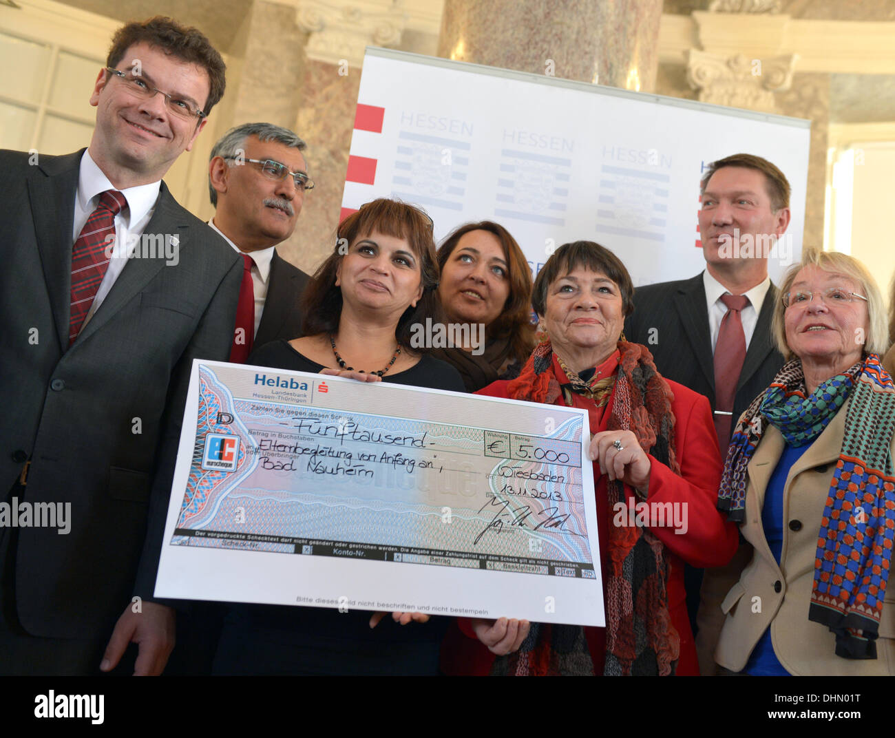Wiesbaden, Allemagne. 13 nov., 2013. Le maire de Bad Nauheim, Armin Haeuser (CDU, L) et les membres du projet "Elternbegleitung von Anfang an' (lit. Soutien pour les parents de début) tenir une coche à côté de laudator Kubilay Kenan et membre du jury (2e L) lors de l'attribution de l'Integrationspreis (lit.) prix de l'intégration à Wiesbaden, Allemagne, 13 novembre 2013. Cette année, quatre projets d'intégration exemplaire pour les familles sont en cours d'attribution. Photo : ARNE DEDERT/dpa/Alamy Live News Banque D'Images