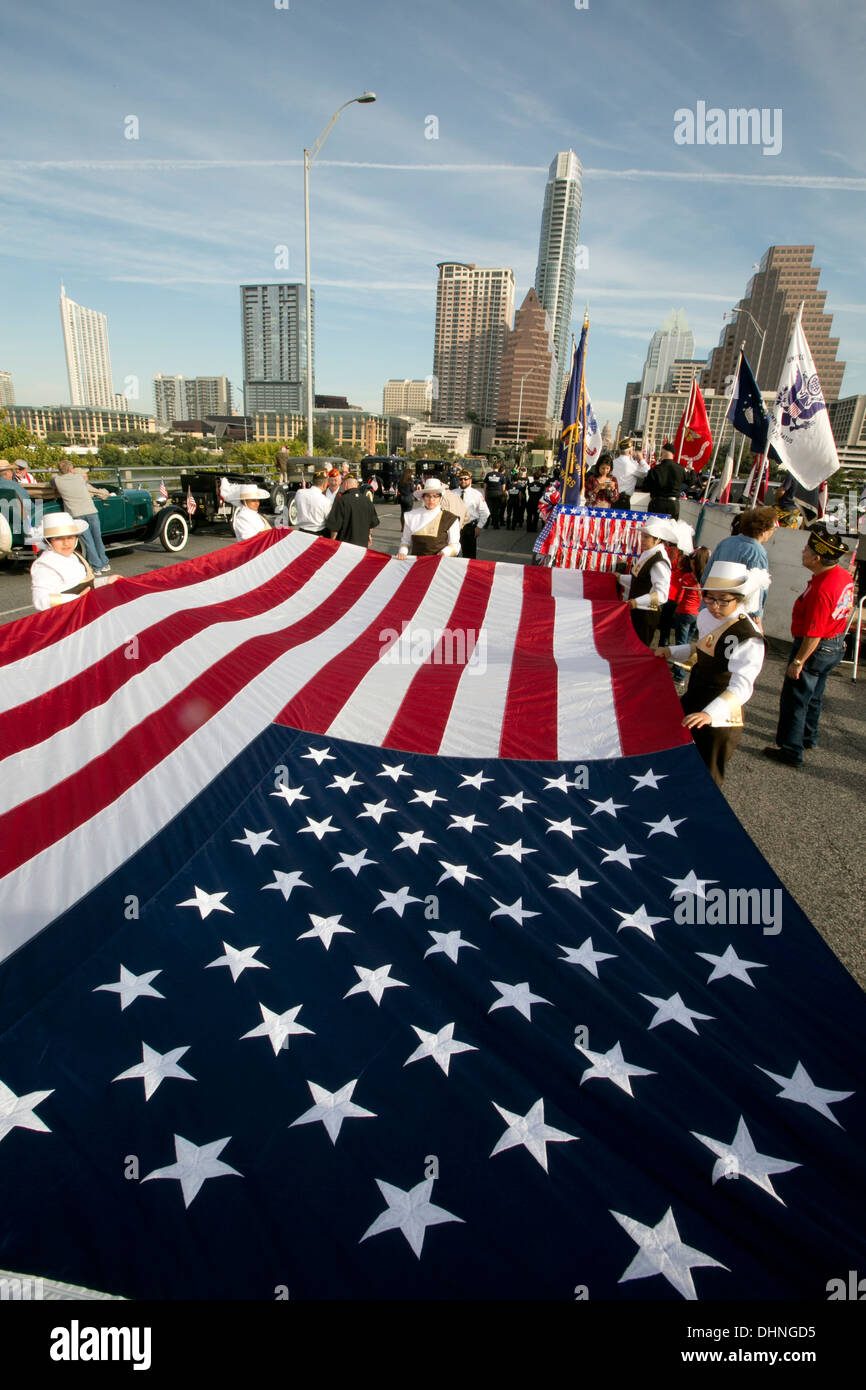 Militaires et civils participer holding grand drapeau américain lors d'un défilé des anciens combattants à Austin, Texas Banque D'Images