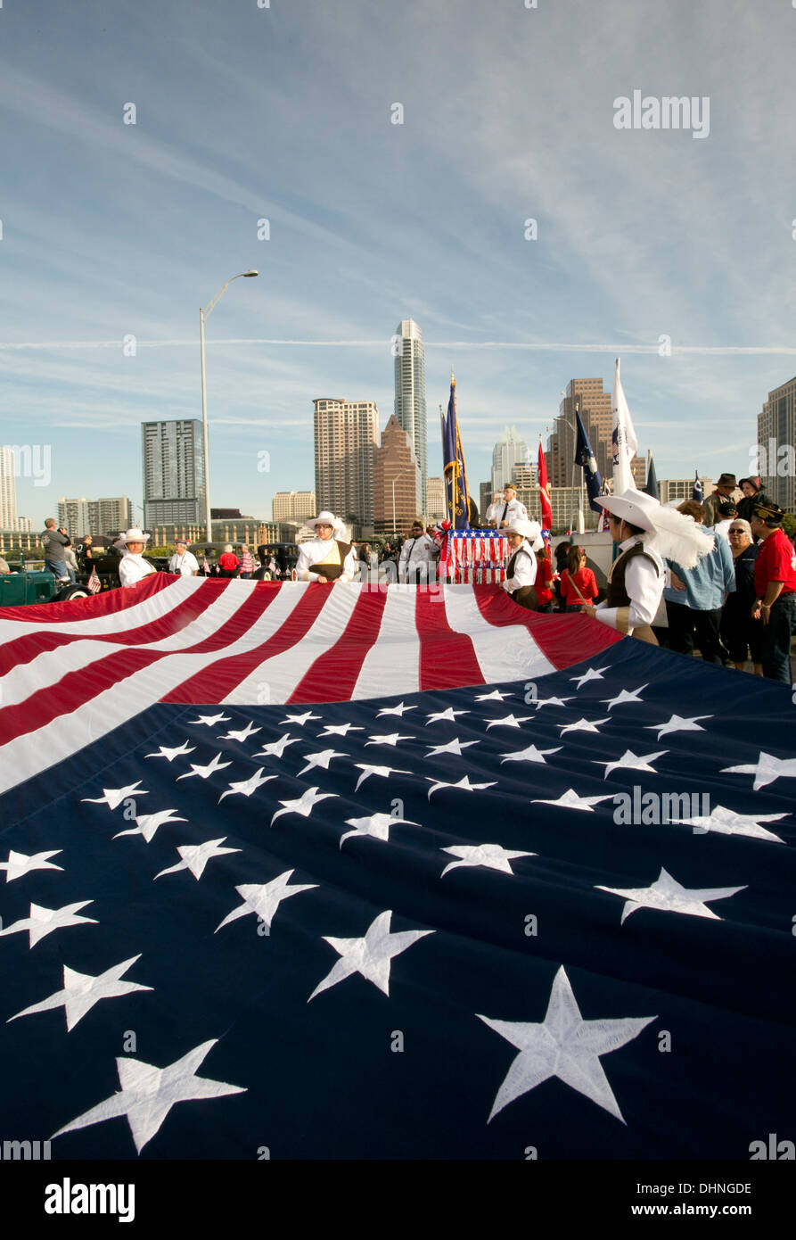 Militaires et civils participer holding grand drapeau américain lors d'un défilé des anciens combattants à Austin, Texas Banque D'Images