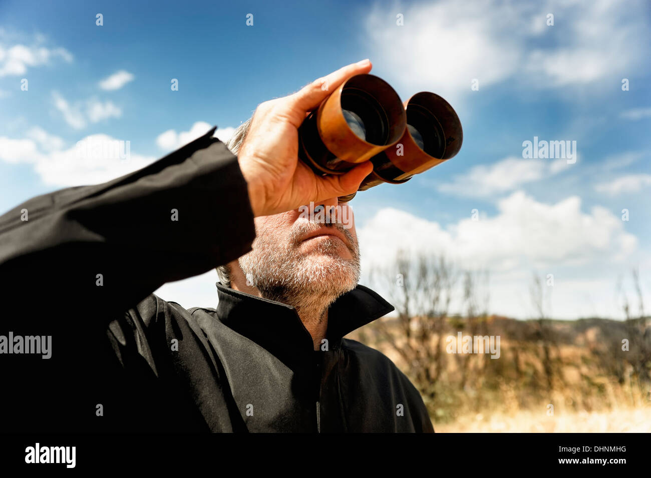 Homme avec les jumelles dans un champ Banque D'Images