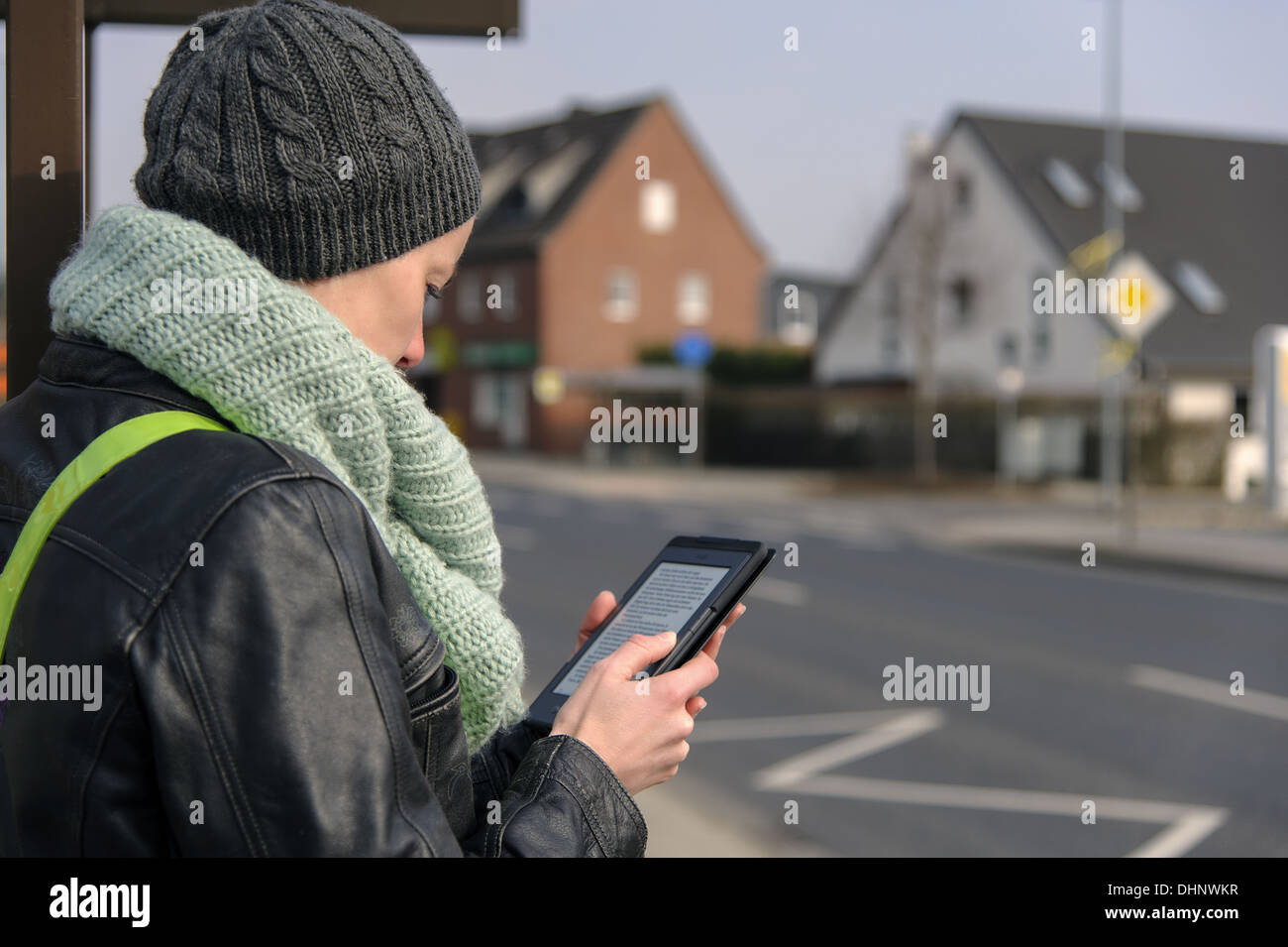 Jeune femme avec du livre électronique sur le bord de la route Banque D'Images