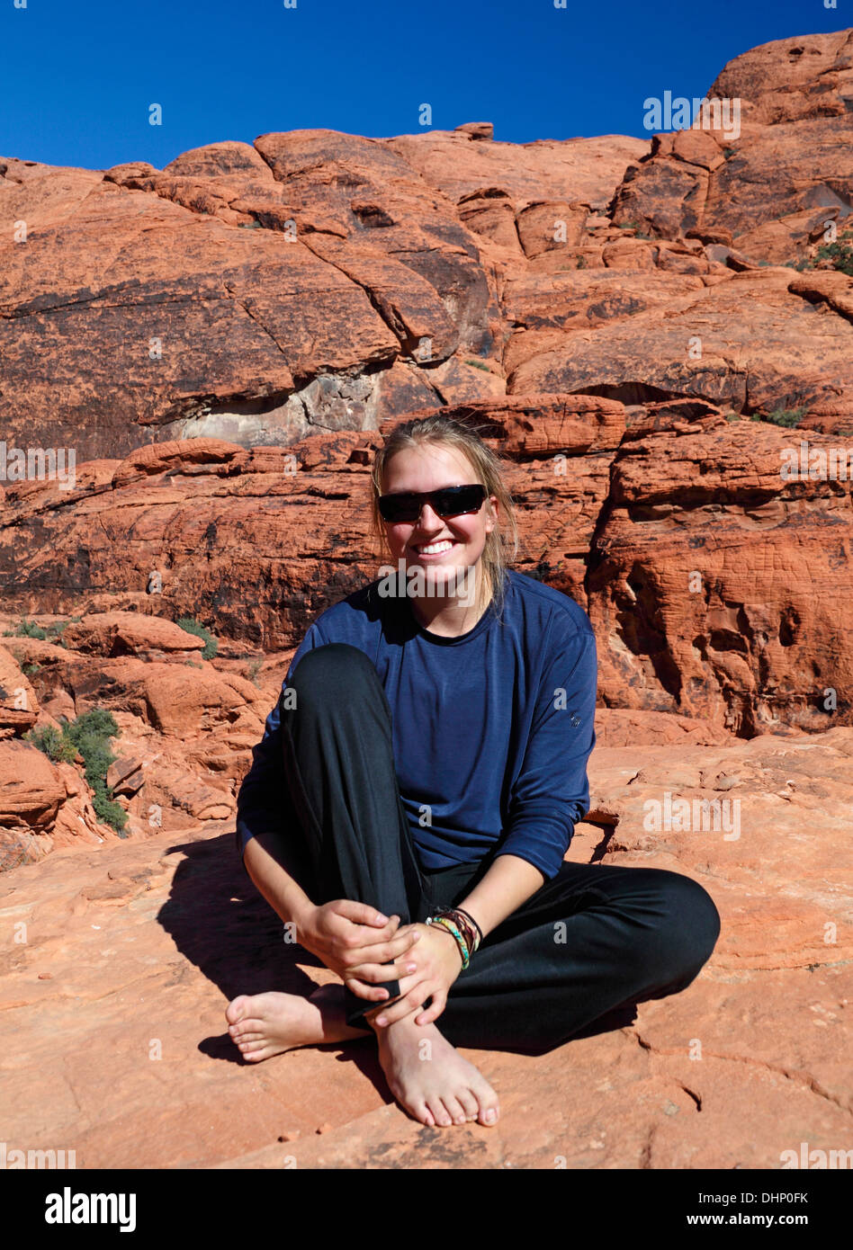 Femme se détend sur falaise au Red Rock Canyon National Conservation Area, à environ 20 minutes de Las Vegas ; elle pratique le highlining Banque D'Images