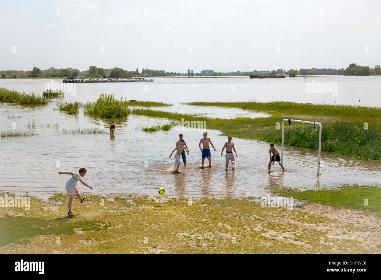 Pays-bas, Ochten, les garçons jouent au football dans les plaines d'inondation inondé de la rivière Waal en raison de l'eau élevée. Banque D'Images