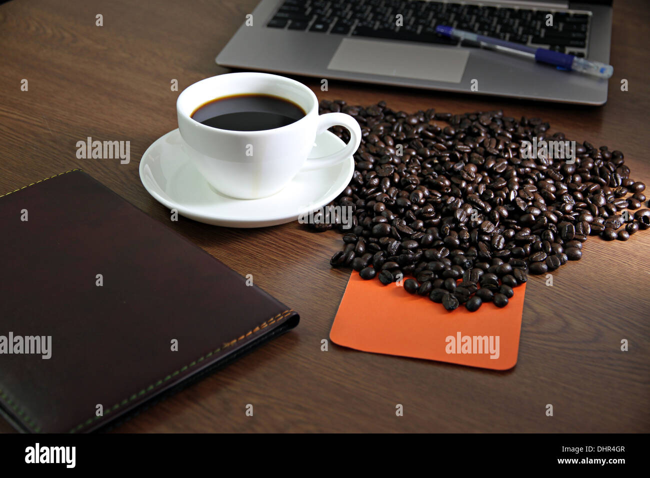 Photo focus White Coffee cup et l'ordinateur sur une table en bois et feuilles de carnet coincé. Banque D'Images