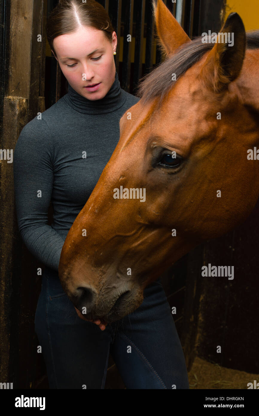 Femme donner une friandise à cheval, format vertical Banque D'Images