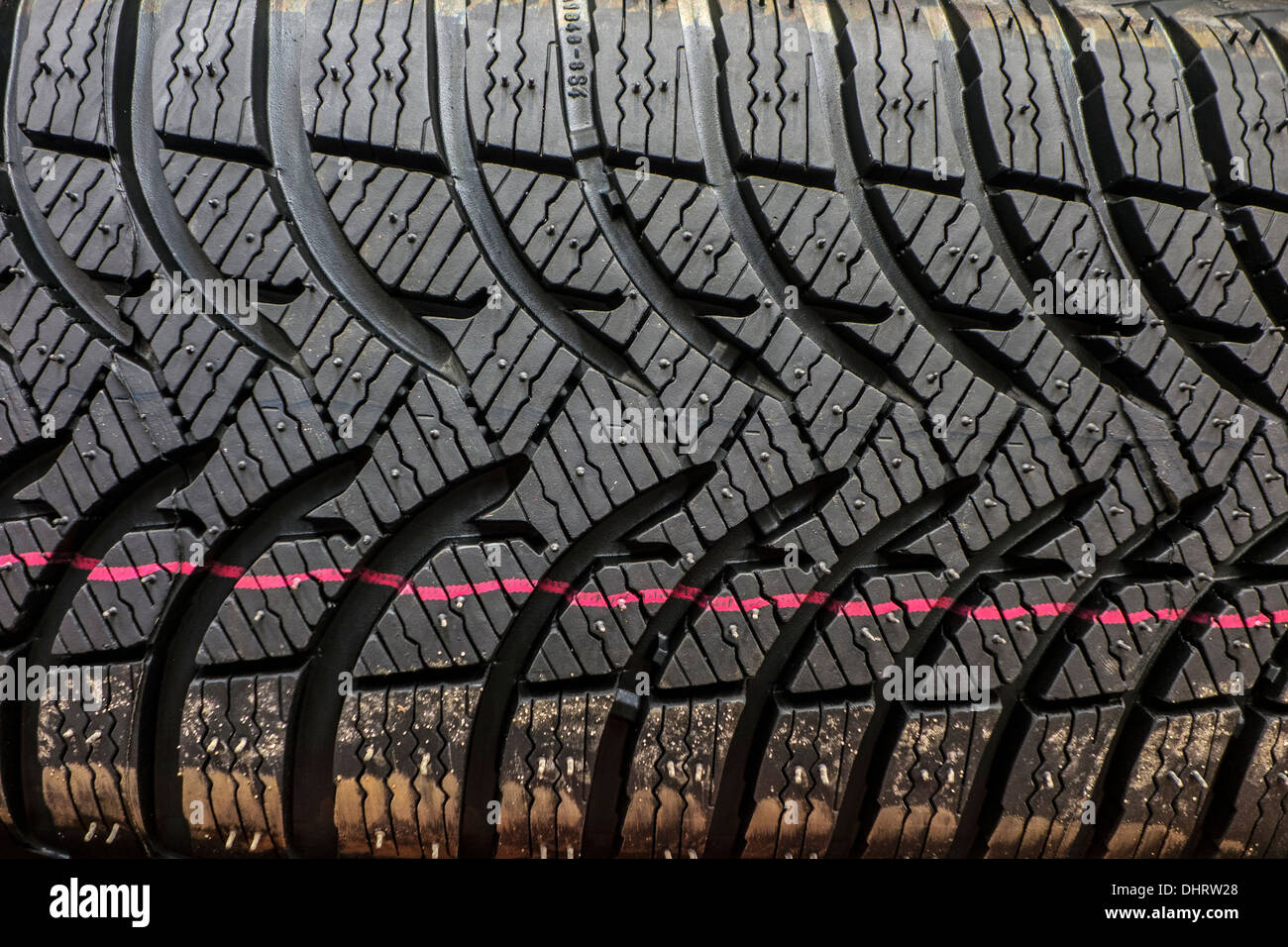 Close up de nouveau pneu hiver / pneu neige pour voiture montrant la bande de roulement en caoutchouc avec des rainures profondes et profil des lamelles supplémentaires Banque D'Images